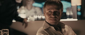 Movie still from “RocknRolla” (2008), directed by Guy Ritchie – A person wearing a white shirt; Close Up shot, Over the shoulder angle