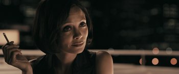 Movie still from “RocknRolla” (2008), directed by Guy Ritchie – A person sitting in front of a window; Close Up shot, Over the shoulder angle