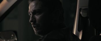 Movie still from “RocknRolla” (2008), directed by Guy Ritchie – A man's face in the dark; Close Up shot, Over the shoulder angle
