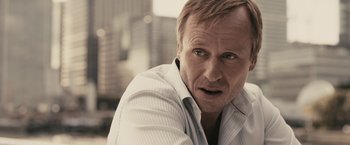 Movie still from “RocknRolla” (2008), directed by Guy Ritchie – A person wearing a white shirt; Close Up shot, Over the shoulder angle