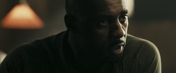 Movie still from “RocknRolla” (2008), directed by Guy Ritchie – A man's face in the dark; Close Up shot, Over the shoulder angle