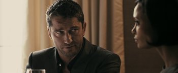 Movie still from “RocknRolla” (2008), directed by Guy Ritchie – A person wearing a jacket; Close Up shot, Over the shoulder angle
