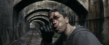 Movie still from “RocknRolla” (2008), directed by Guy Ritchie – A man with blood on his face and a black glove; Close Up shot, Low angle
