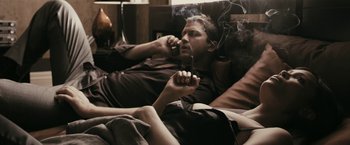 Movie still from “RocknRolla” (2008), directed by Guy Ritchie – A man smoking a cigarette while talking on the phone; Medium shot, High angle