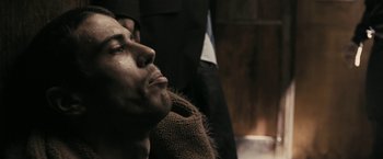 Movie still from “RocknRolla” (2008), directed by Guy Ritchie – A person with his eyes closed; Close Up shot, Low angle