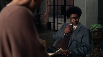 Movie still from “Roman J. Israel, Esq.” (2017), directed by Dan Gilroy – A man in a suit and tie holding a book; Medium shot, Over the shoulder angle
