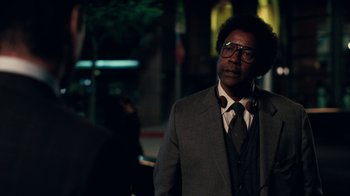 Movie still from “Roman J. Israel, Esq.” (2017), directed by Dan Gilroy – A man in a suit and tie standing in a street; Close Up shot, Over the shoulder angle