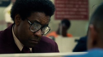 Movie still from “Roman J. Israel, Esq.” (2017), directed by Dan Gilroy – A man with glasses looking down at a table; Close Up shot, Over the shoulder angle