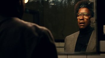 Movie still from “Roman J. Israel, Esq.” (2017), directed by Dan Gilroy – A man looking into a bathroom mirror while wearing glasses; Close Up shot, Over the shoulder angle