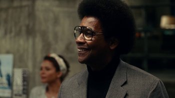 Movie still from “Roman J. Israel, Esq.” (2017), directed by Dan Gilroy – A man in a suit and glasses smiling for the camera; Close Up shot, Over the shoulder angle
