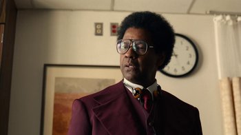 Movie still from “Roman J. Israel, Esq.” (2017), directed by Dan Gilroy – A man in a suit and tie standing in front of a clock; Close Up shot, Over the shoulder angle