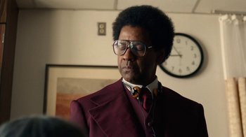 Movie still from “Roman J. Israel, Esq.” (2017), directed by Dan Gilroy – A man in a suit and tie standing in front of a clock; Close Up shot, Low angle