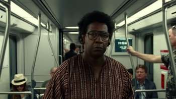 Movie still from “Roman J. Israel, Esq.” (2017), directed by Dan Gilroy – A man with glasses is standing on a train; Medium shot, Over the shoulder angle