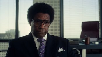 Movie still from “Roman J. Israel, Esq.” (2017), directed by Dan Gilroy – A man in a suit and tie in front of a window; Close Up shot, Over the shoulder angle