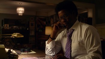 Movie still from “Roman J. Israel, Esq.” (2017), directed by Dan Gilroy – A man sitting at a table talking on a phone; Close Up shot, Over the shoulder angle