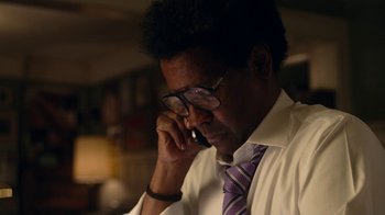 Movie still from “Roman J. Israel, Esq.” (2017), directed by Dan Gilroy – A man in a white dress shirt and purple tie talking on a cell phone; Close Up shot, Low angle