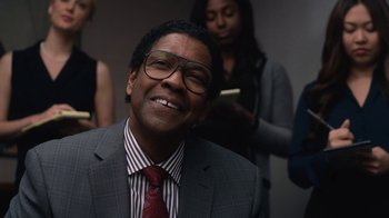 Movie still from “Roman J. Israel, Esq.” (2017), directed by Dan Gilroy – A man in a suit and tie smiling for the camera; Close Up shot, Over the shoulder angle