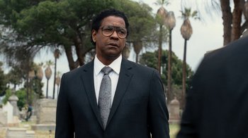Movie still from “Roman J. Israel, Esq.” (2017), directed by Dan Gilroy – A man in a suit and tie standing in front of trees; Medium shot, Over the shoulder angle