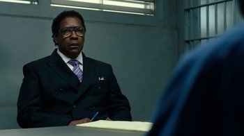 Movie still from “Roman J. Israel, Esq.” (2017), directed by Dan Gilroy – A man sitting at a table in a suit and tie; Close Up shot, Over the shoulder angle