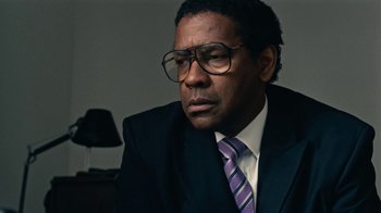 Movie still from “Roman J. Israel, Esq.” (2017), directed by Dan Gilroy – A man in a suit and tie sitting in front of a lamp; Close Up shot, Over the shoulder angle