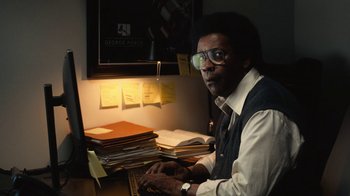 Movie still from “Roman J. Israel, Esq.” (2017), directed by Dan Gilroy – A man sitting in front of a computer desk; Medium shot, Low angle