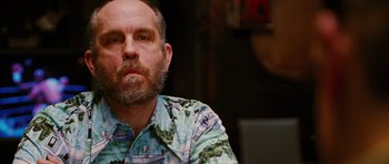 Movie still from “Rounders” (1998), directed by John Dahl – A man with a beard wearing a hawaiian shirt; Close Up shot, Over the shoulder angle