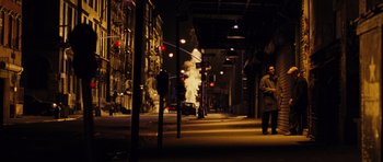 Movie still from “Rounders” (1998), directed by John Dahl – A man standing on the side of a street at night; Extreme Wide shot, Low angle