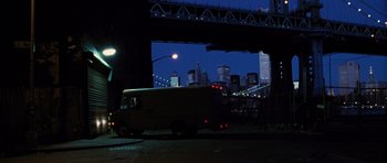 Movie still from “Rounders” (1998), directed by John Dahl – A van driving under a bridge at night with lights; Extreme Wide shot, Low angle