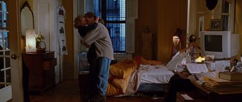 Movie still from “Rounders” (1998), directed by John Dahl – A man and a woman kissing in front of a bed; Wide shot, Low angle