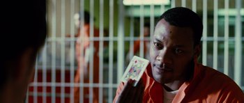 Movie still from “Rounders” (1998), directed by John Dahl – A man holding a deck of playing cards in front of a jail cell; Close Up shot, Over the shoulder angle