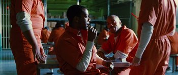 Movie still from “Rounders” (1998), directed by John Dahl – Two men in orange jumpsuits sitting in a room; Medium shot, Low angle