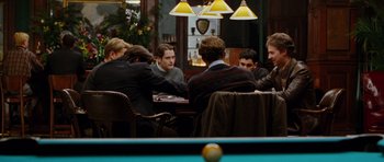 Movie still from “Rounders” (1998), directed by John Dahl – A group of people sitting around a table; Medium shot, Over the shoulder angle