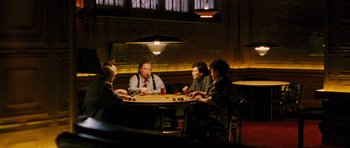 Movie still from “Rounders” (1998), directed by John Dahl – A group of people sitting around a table playing a game; Wide shot, High angle