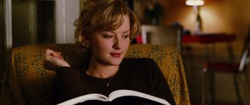 Movie still from “Rounders” (1998), directed by John Dahl – A woman sitting in a chair reading a book; Close Up shot, High angle