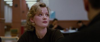 Movie still from “Rounders” (1998), directed by John Dahl – A woman with blonde curly hair sitting in a room; Close Up shot, Over the shoulder angle