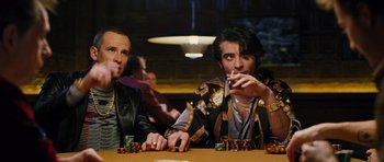 Movie still from “Rounders” (1998), directed by John Dahl – A couple of men sitting at a table with some chips; Medium shot, Over the shoulder angle