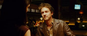Movie still from “Rounders” (1998), directed by John Dahl – A man wearing a brown leather jacket talking to a woman; Close Up shot, Over the shoulder angle