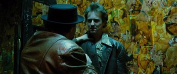 Movie still from “Rounders” (1998), directed by John Dahl – A man in a leather jacket is looking at another man in a hat; Close Up shot, Over the shoulder angle