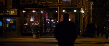 Movie still from “Rounders” (1998), directed by John Dahl – A man standing on the side of the street at night; Wide shot, Over the shoulder angle
