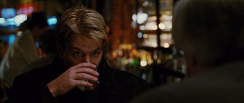 Movie still from “Rounders” (1998), directed by John Dahl – A man drinking a glass of wine in a bar; Close Up shot, Over the shoulder angle