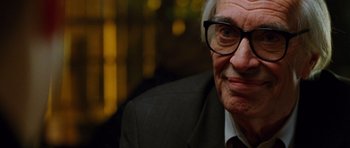 Movie still from “Rounders” (1998), directed by John Dahl – An older man wearing glasses and a suit; Close Up shot, Over the shoulder angle