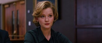 Movie still from “Rounders” (1998), directed by John Dahl – A woman with blonde hair sitting in front of a picture; Close Up shot, Over the shoulder angle