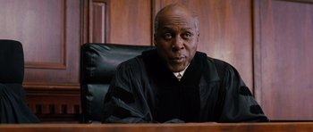 Movie still from “Rounders” (1998), directed by John Dahl – A judge sitting in front of a judge's chair; Close Up shot, Low angle