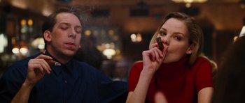 Movie still from “Rounders” (1998), directed by John Dahl – A man and a woman are sitting in front of each other and smoking; Close Up shot, Over the shoulder angle