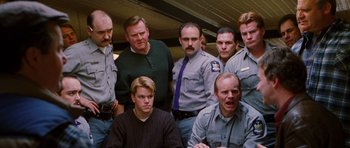 Movie still from “Rounders” (1998), directed by John Dahl – A group of men standing next to each other in a room; Medium shot, Low angle