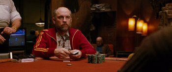 Movie still from “Rounders” (1998), directed by John Dahl – A man sitting at a table in front of stacks of poker chips; Medium shot, Over the shoulder angle