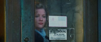 Movie still from “Rounders” (1998), directed by John Dahl – A woman looking out of a window at a smoking area; Close Up shot, Low angle