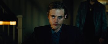 Movie still from “Run All Night” (2015), directed by Jaume Collet-Serra – A man in a black suit and blue shirt; Close Up shot, Low angle