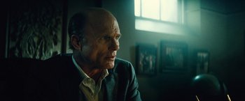 Movie still from “Run All Night” (2015), directed by Jaume Collet-Serra – An older man sitting in front of a window; Close Up shot, Low angle