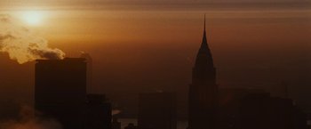 Movie still from “Run All Night” (2015), directed by Jaume Collet-Serra – The sun is setting over a city skyline; Extreme Wide shot, Low angle